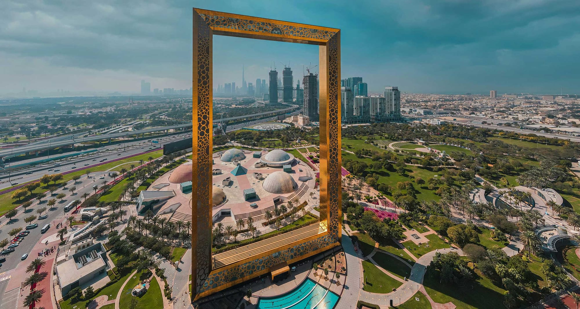 Giant picture frame structure in front of Dubai skyline.