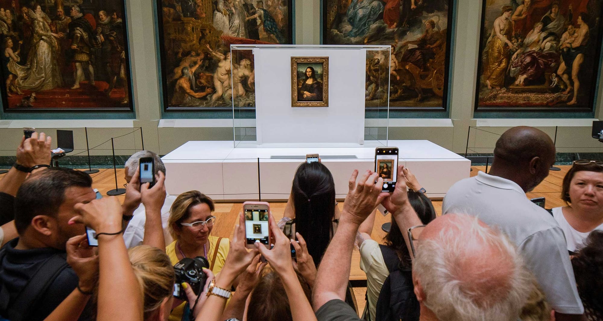 People crowded around the Mona Lisa painting to take pictures.