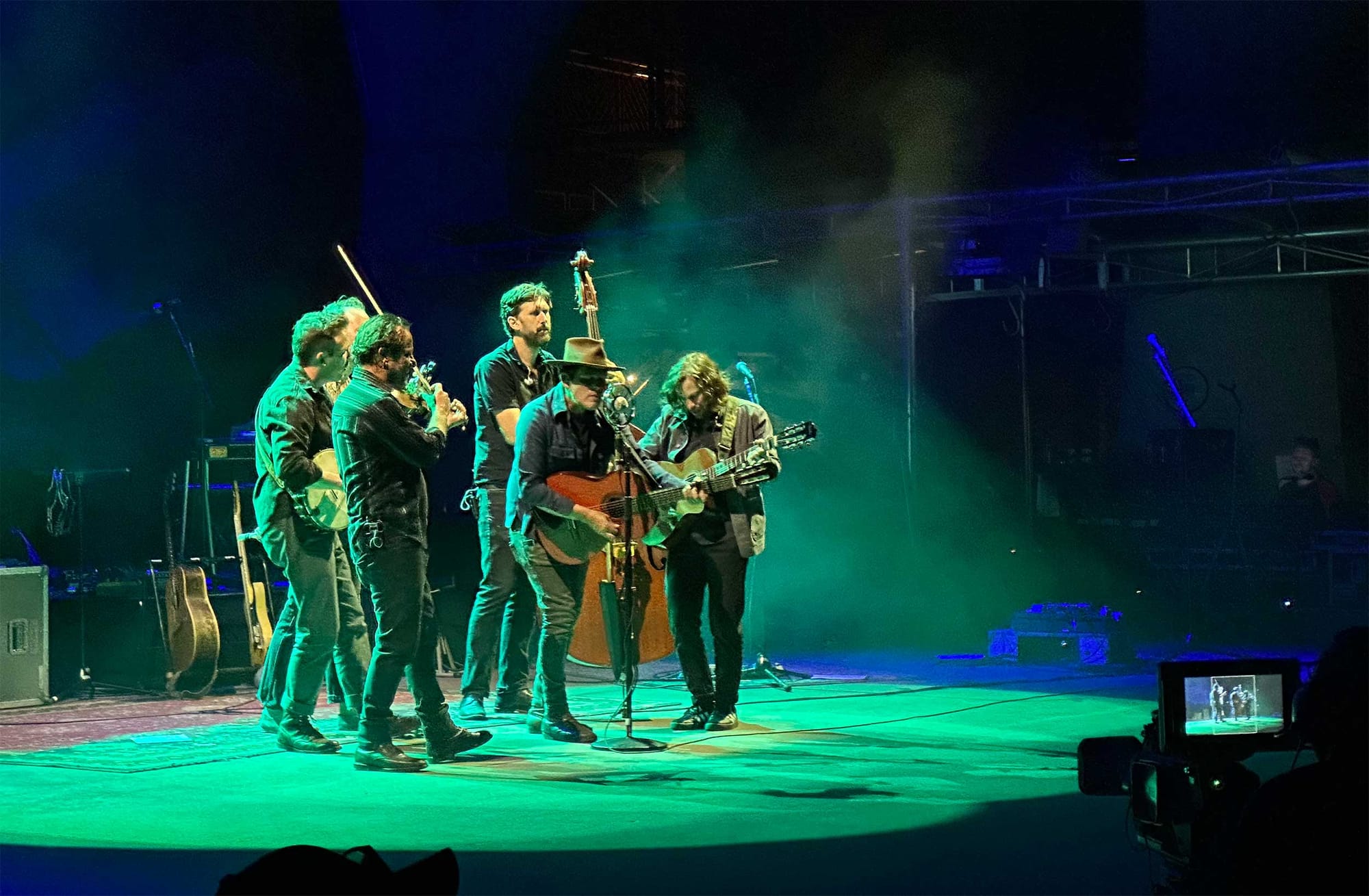 Musicians gathered in a close circle around a microphone onstage.