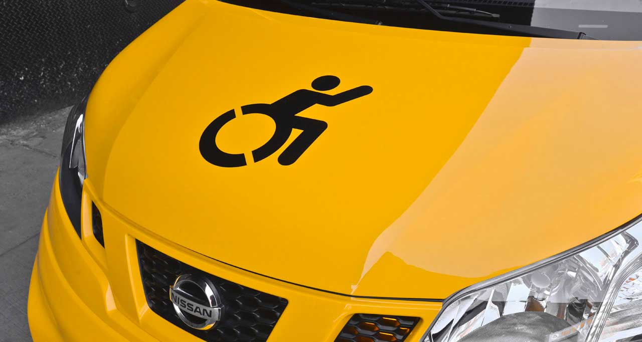 Hood of yellow taxi van with wheelchair icon.