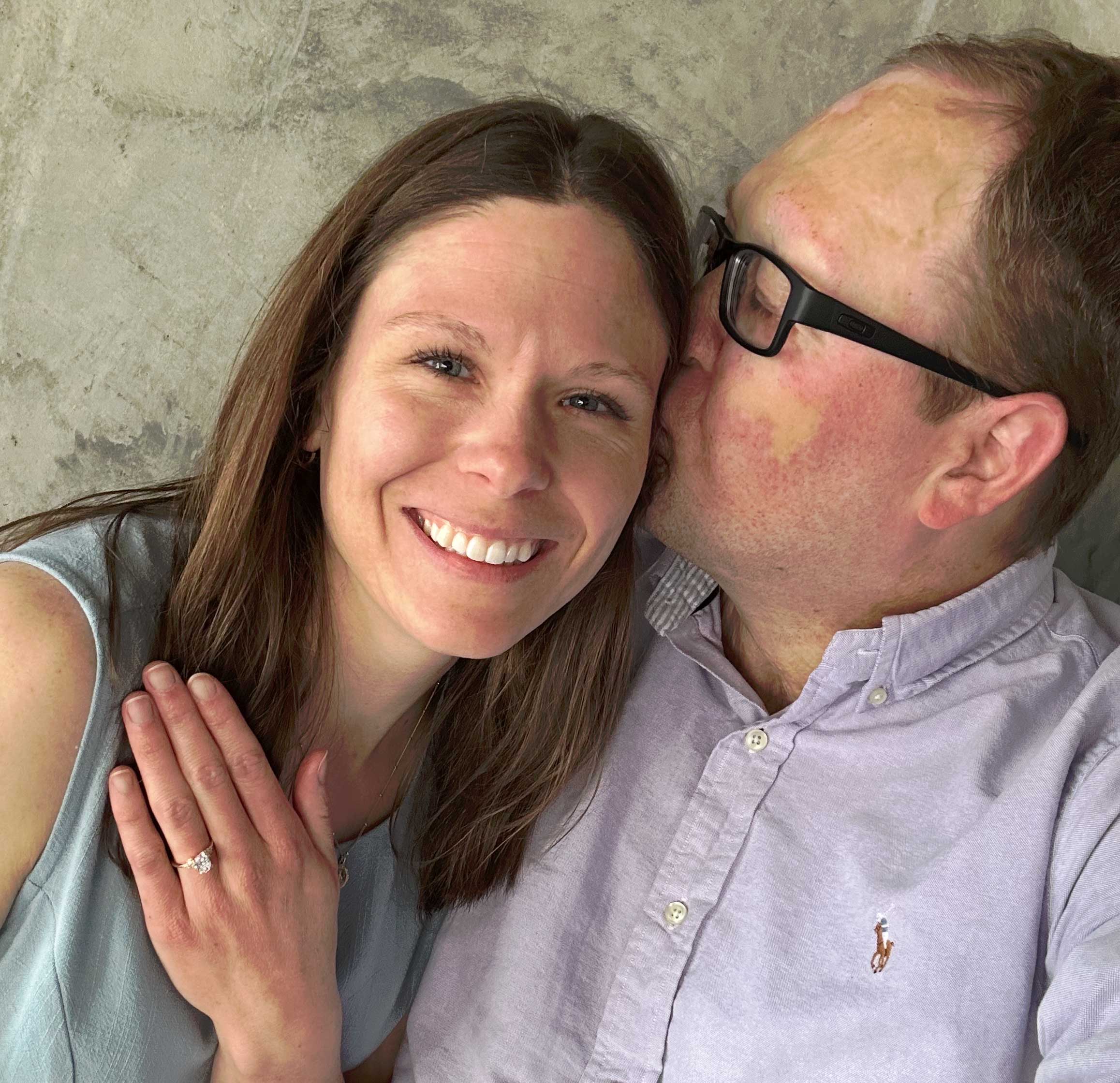 John kissing his fiancee on the cheek.