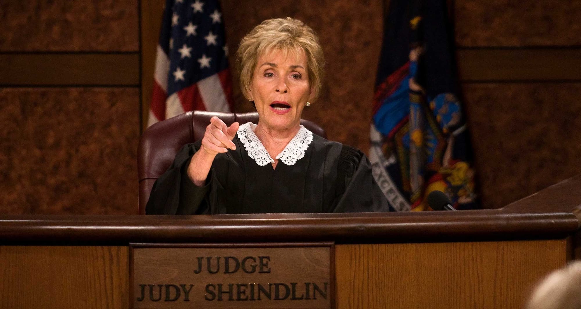 Judith Sheindlin wearing judicial robes and seated in a courtroom.