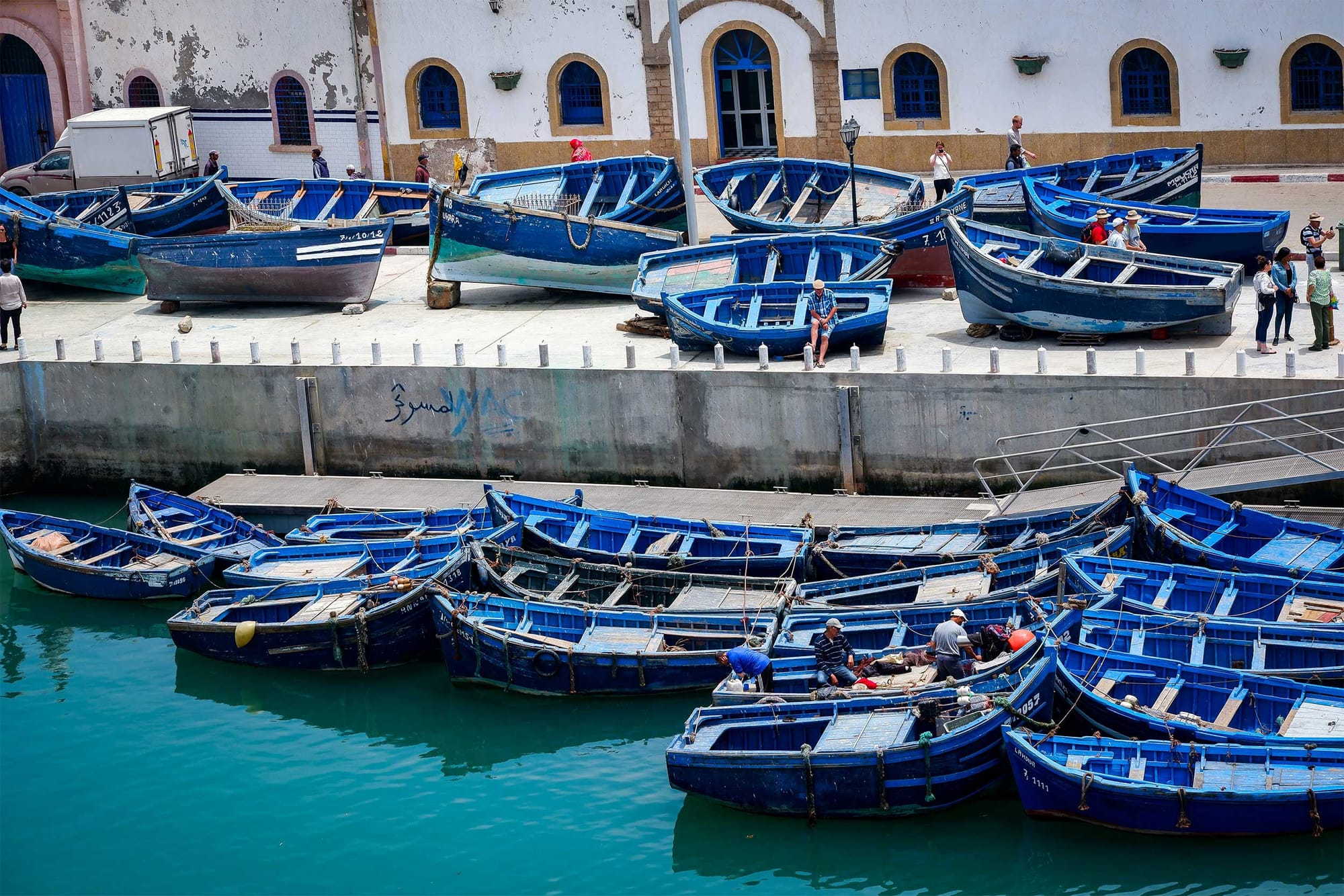 Fishing boats parked in the water and on a dock.