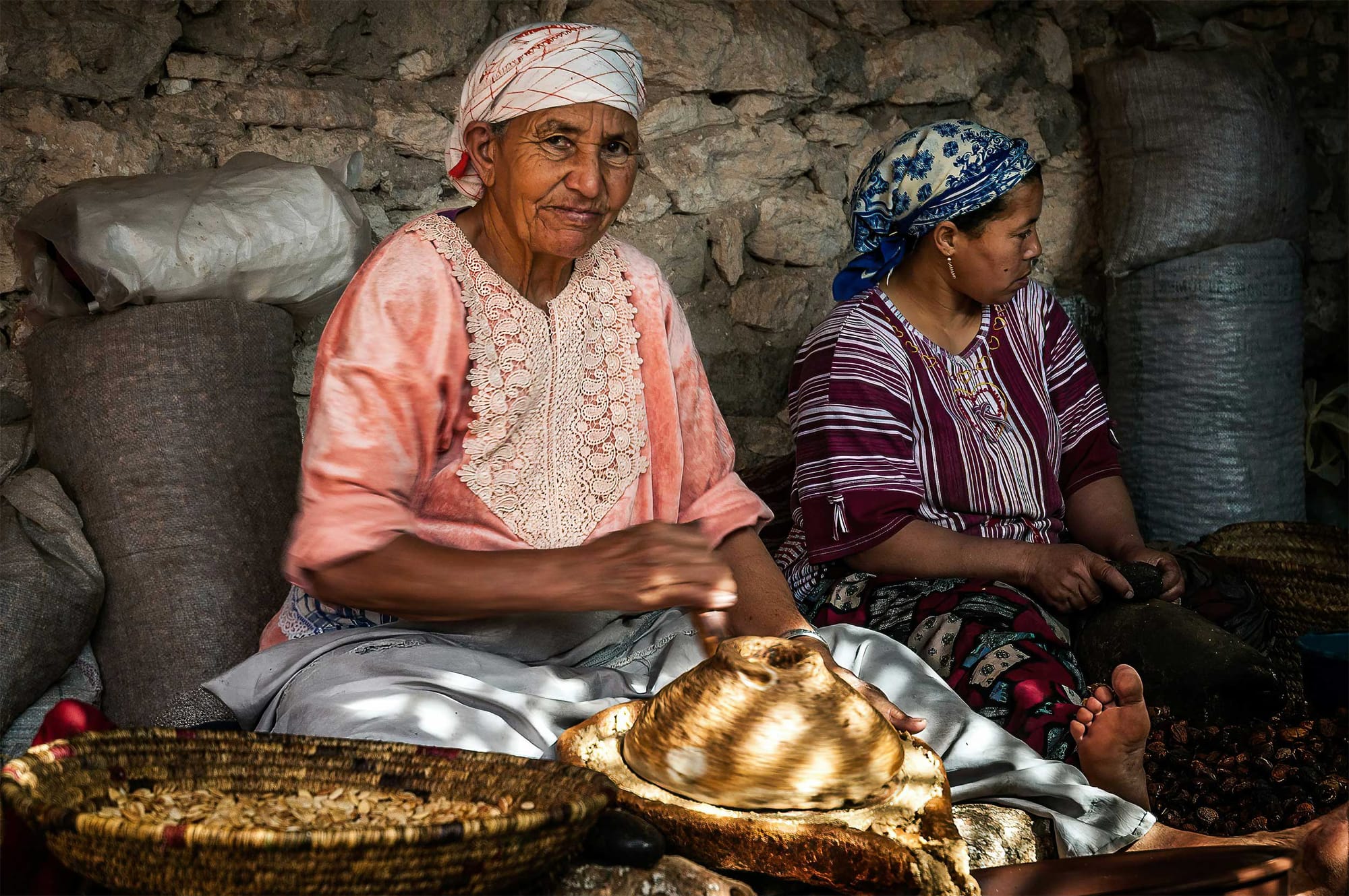 Moroccan women seated and creating a local product.