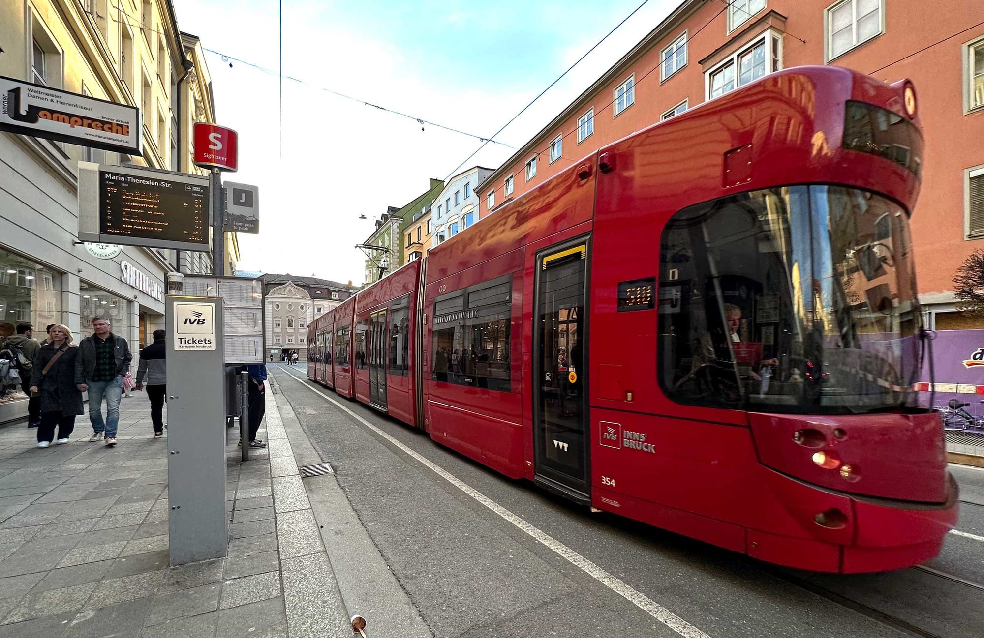 Red tram on street in Austria.
