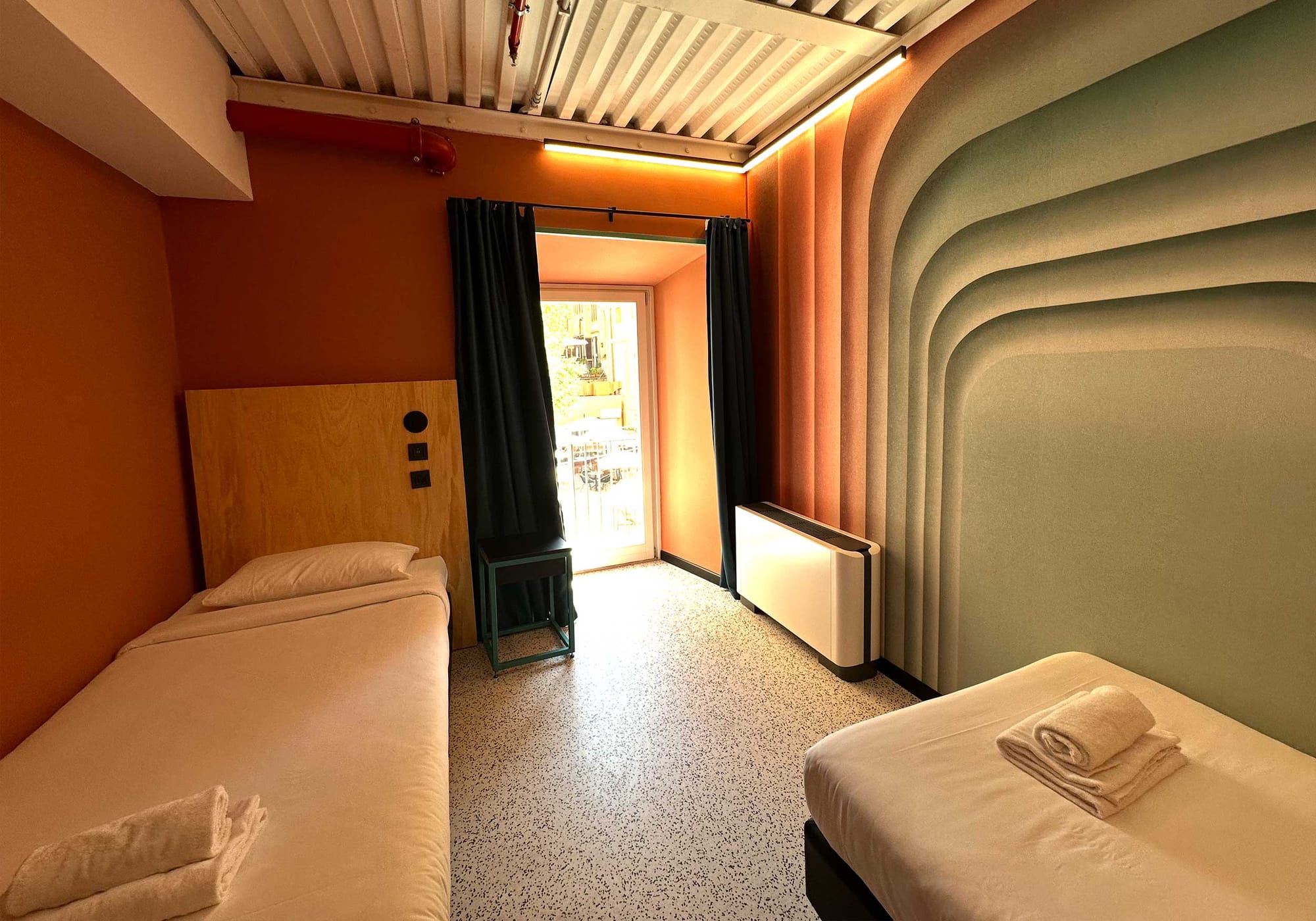 Two single beds, air conditioning unit and window.
