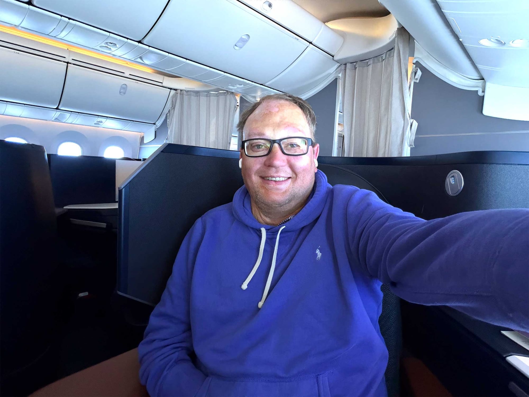 Selfie of John seated in business class seat.