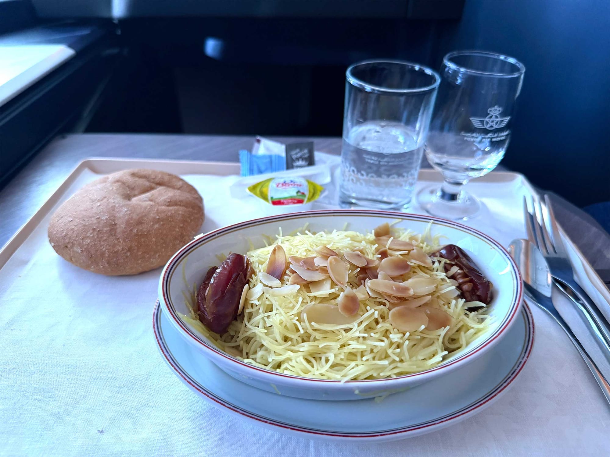 Main course with a chicken pasta and bread.