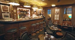 Bartender working behind a small, intimate, historic bar.