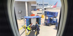 American Airlines team lifting a power wheelchair onto the airplane.