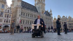 Wheelchair user in Brussels city square.