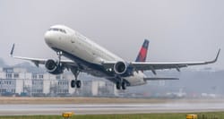 Delta Air Lines Airbus A321 taking off from foggy runway.