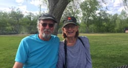 Jake and his wife Louise sitting in a park with a large tree behind them.