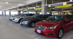 Rental cars lined up in a parking garage.