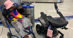 Engracia Figueroa sitting in an airport wheelchair next to her damaged power wheelchair.