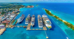 Aerial view of multiple cruise ships docked at port in a tropical destination.