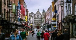 Busy street in Dublin, Ireland leading towards a cathedral.