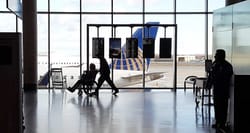 Disabled and elderly passenger being pushed through the airport terminal in a wheelchair.