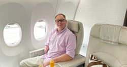 John seated in a business class cabin on Fiji Airways.