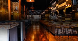 Steakhouse restaurant and bar area with booths and tables.