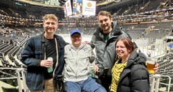 John pictured with three friends in front of the ice hockey rink at the Boston Bruins arena.