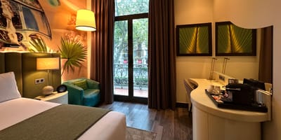 Queen size bed in wheelchair accessible hotel room.