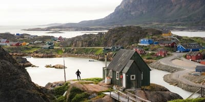 Houses spread across a rocky and hilly area in a Greenland village.