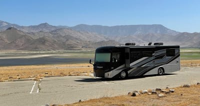 Winnebago Inspire parked in front of lake and mountains.