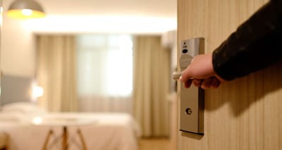 Person opening door into hotel room.