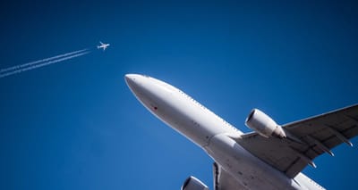 Two airplanes at altitude passing in different directions.