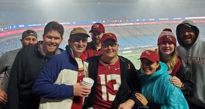 John and a group of friends at a college football game.