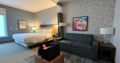 Large hotel room with king size bed and sofa bed.