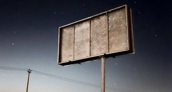 Blank billboard set against a night sky with stars.