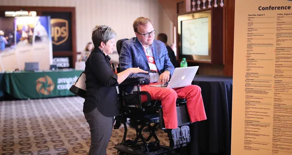 John consulting with a client at a conference.