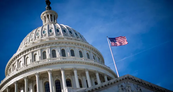 Dome of the United States Capitol Building with an American flag.