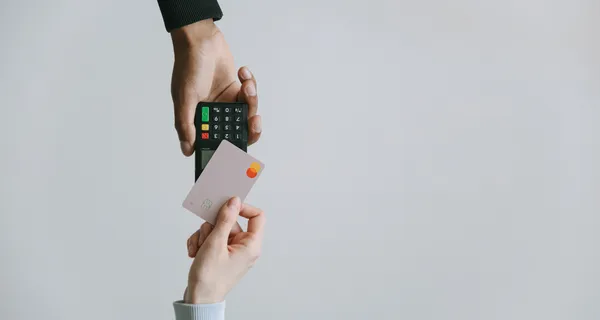 Credit card being tapped on a payment terminal.