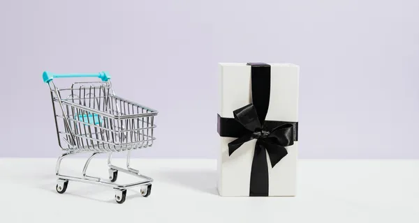 Shopping cart with wrapped gift.