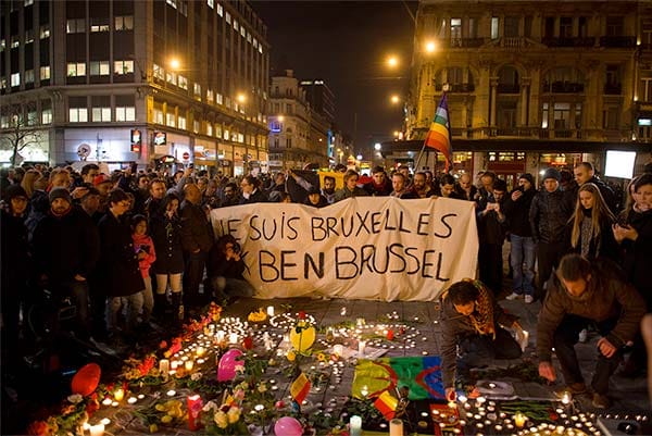 Photo Description: People gathered for a vigil in Brussels, Belgium, holding a sign that reads 'I am Brussels'.