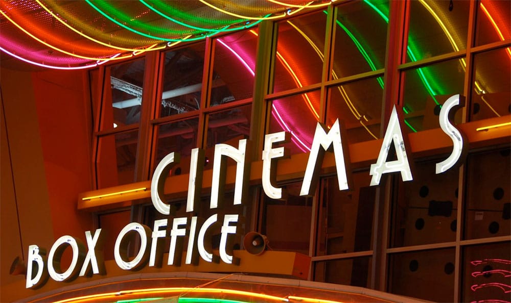 Photo Description: Neon movie theater sign that says 'Cinemas Box Office'.