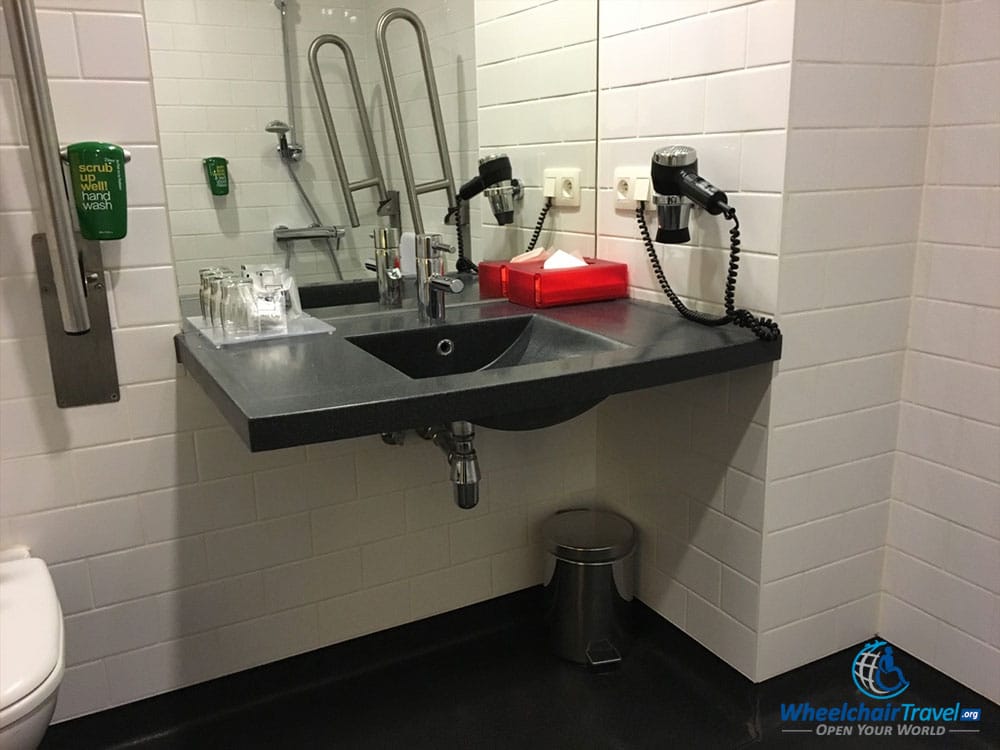 Photo Description: Bathroom sink with space for a person to rull underneath the countertop in a wheelchair.