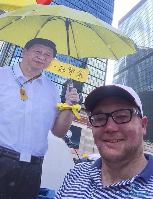 PHHOTO DESCRIPTION: John Morris with a cardboard cut-out of the Chinese President at the Umbrella Movement campsite at Admiralty in Hong Kong.