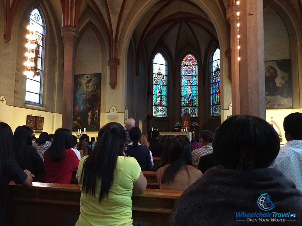 People sitting in prayer before Mass at St. Olav's Cathedral in Oslo, Norway.