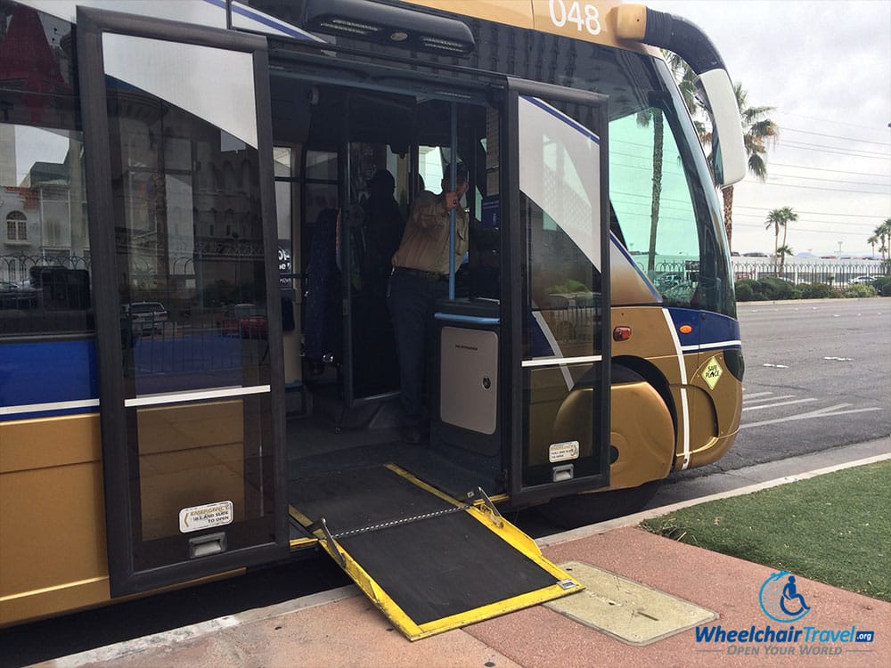 PHOTO DESCRIPTION: A Las Vegas SDX bus at a stop with its wheelchair ramp extended out onto the sidewalk.