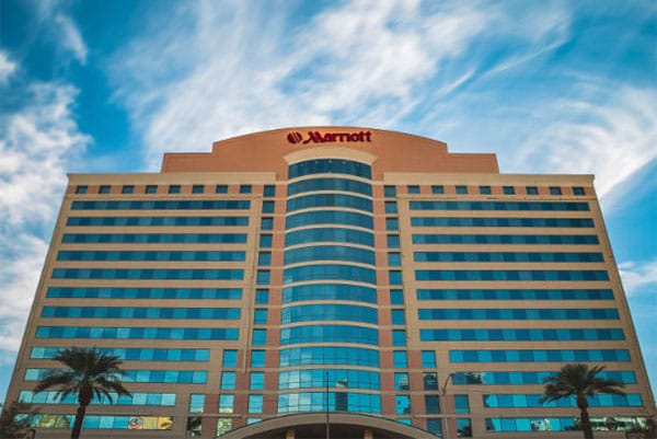 PHOTO DESCRIPTION: Front facade of the Las Vegas Marriott Hotel, set against a blue sky with white clouds.