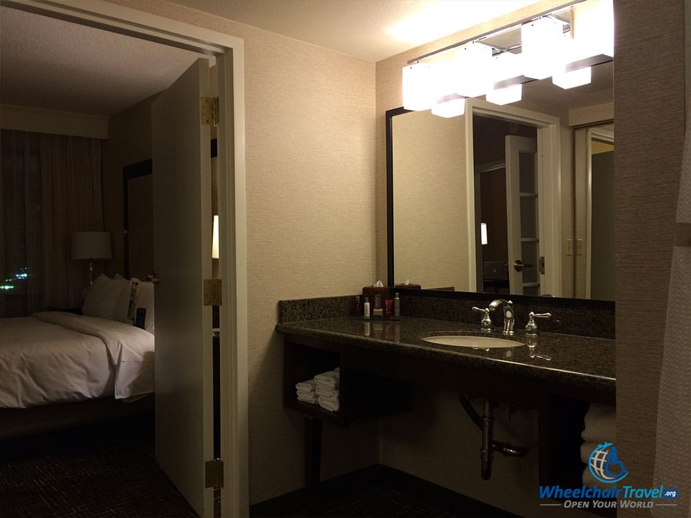 PHOTO DESCRIPTION: Bathroom sink with door leading into the suite's bedroom.