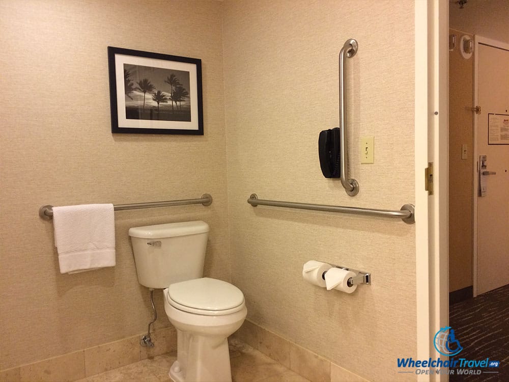 PHOTO DESCRIPTION: A wheelchair accessible bathroom toilet surrounded by grab bars.