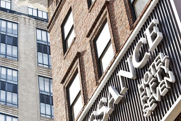 PHOTO DESCRIPTION: A close-up, angled shot of a section of a brick building, with a sign on the front that says 'Renaissance