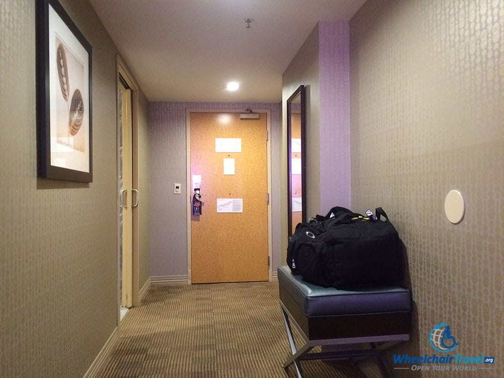 PHOTO DESCRIPTION: Room's interior hallway leading from the bed to the main room door and bathroom.