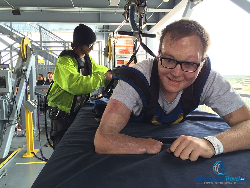 PHOTO DESCRIPTION: A hydraulic mat lifts the passenger up to the zip line, then lowers so that they are suspended.