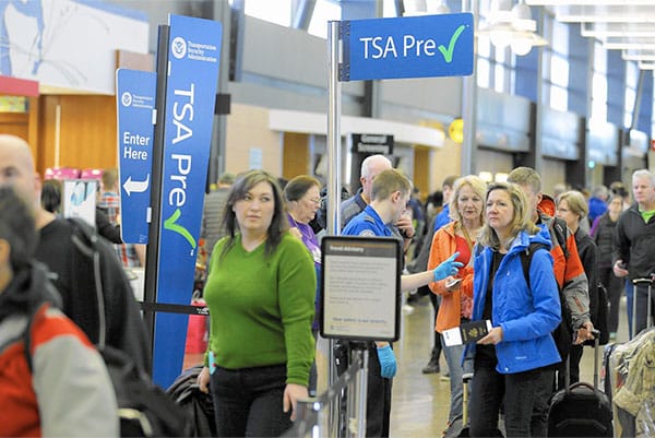 PHOTO DESCRIPTION: Line of passengers at TSA PreCheck airport security checkpoint.